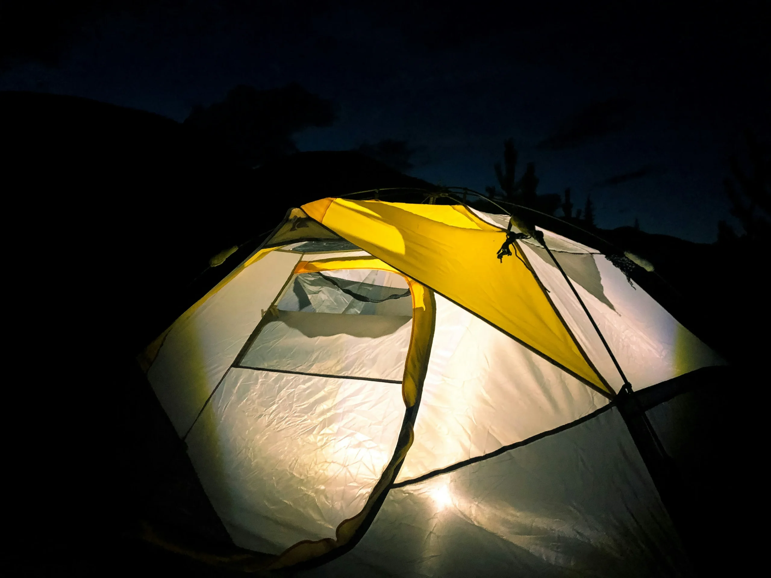 Top 5 lightweight tarps for camping laid out in forest setting