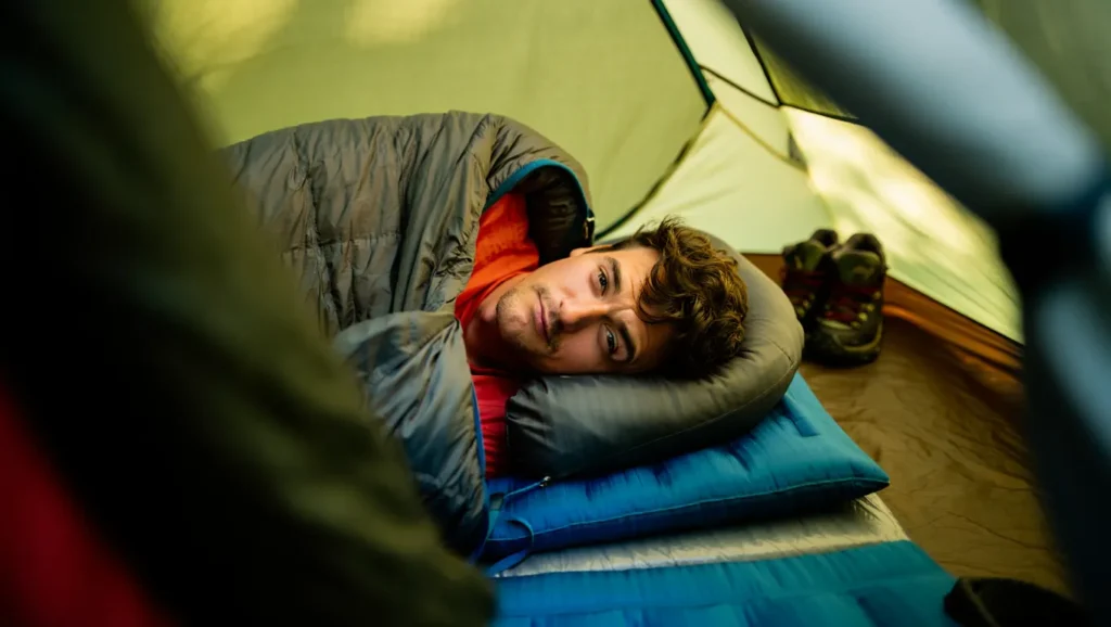 Backpacker sleeping comfortably in a tent on sleeping pad and bag