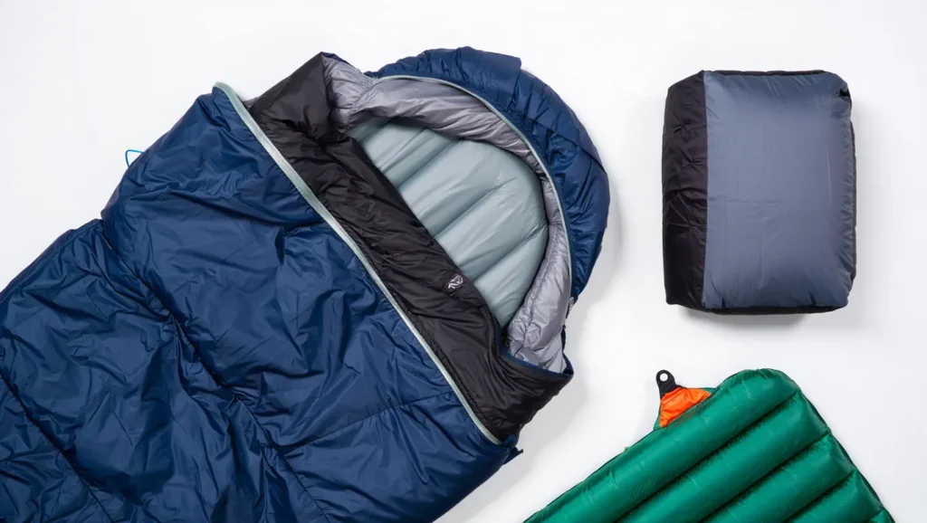 Flat lay of complete backpacking sleep system with sleeping bag, pad and pillow