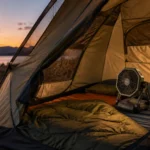 Rechargeable camping fan moving air inside a tent at a summer campsite